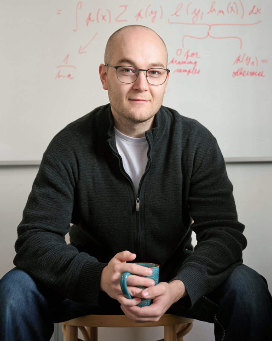 Jakub Paplhám seated in front of a whiteboard